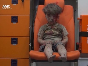 In this frame grab taken from video provided by the Syrian anti-government activist group Aleppo Media Center (AMC), 5-year-old Omran Daqneesh sits in an ambulance after being pulled out or a building hit by an airstirke, in Aleppo, Syria, Wednesday, Aug. 17, 2016.  (Aleppo Media Center via AP)