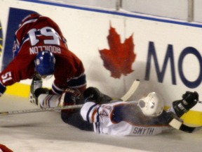Edmonton Oilers forward Smyth takes a hit from Montreal Canadiens Francis Bouillon during the Heritage Classic at Commonwealth Stadium on Nov. 22, 2003.