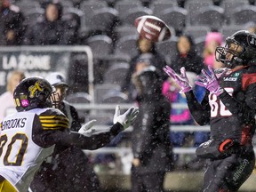 Redblacks receiver Juron Criner (right) catches the ball for a touchdown, despite Hamilton’s Derrius Brooks trying to get the pick at TD Place last night. Hamilton won 39-36 in overtime. (Wayne Cuddington/Postmedia Network)