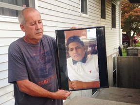 In this Sept. 27, 2016 file photo, Abraham Chaparro, holds a photograph of his murdered stepson, Miguel Garcia-Moran, outside his home in Brentwood, N.Y. Garcia-Moran is among four teenagers from Brentwood High School that have been found dead this past month in a string of brutal killings that assistant Suffolk County Police Commissioner Justin Meyers says may be tied to gang violence. (AP Photo/Claudia Torrens, File)