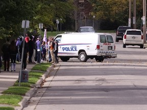 A police van patrols on Broughdale Avenue as a small group of homecoming revellers gathers on the largely student-populated street that has become synonymous with large parties on homecoming weekends in years past. Craig Glover/The London Free Press/Postmedia