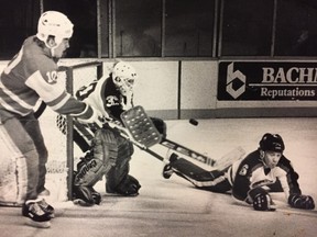 Sun columnist Doug Lunney, a goaltender with the Winnipeg Warriors in 1983-84, faces a puck against the Saskatoon Blades along with defenceman, Cory Picknicki, who became a teacher at Westwood Collegiate.  (Sun file photo)