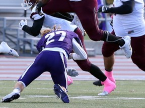 McMaster Marauders wide receiver Aaron Baker hurdles over Western Mustangs defensive back Mackenzie Ferguson as he carries the ball during their university football game at TD Stadium in London, Ont. on Saturday October 22, 2016. Western won the homecoming game 19-18. (CRAIG GLOVER, The London Free Press)