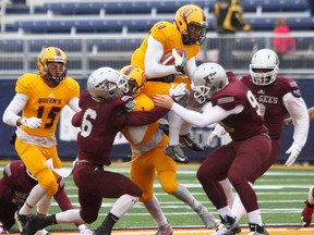 Queen's Chris Mackey tries to leap over the Gee-Gees defensive line during Ontario University Athletics action at Richardson Stadium in Kingston, Ont. on Saturday October 22, 2016. The Gaels fell to the Gee-Gees in overtime 42-41. Steph Crosier/Kingston Whig-Standard/Postmedia Network