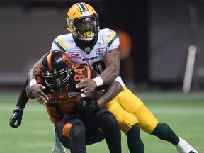 Edmonton Eskimos linebacker Deon Lacey (40) tackles BC Lions slotback Emmanuel Arceneaux (84) during the second half of CFL football action, in Vancouver on Saturday, Oct. 22, 2016.