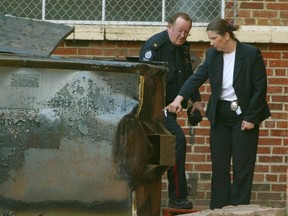 Det. Catherine Oakden and Insp. Dick Shantz inspect an Old Strathcona garbage bin where the burned body of Cheryl Black was found in May 2004. (Brian Gavriloff/Postmedia)