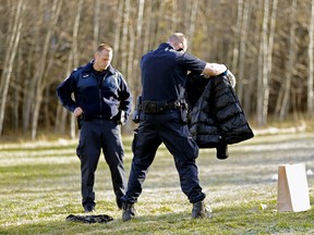 Police collect clothing and a mobile phone found near the scene of a suspicious death near Fox Drive in Edmonton on Sunday Oct. 23, 2016. (Larry Wong/Postmedia)