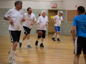 Don Kuiken (with the ball) joined the Staff Basketball Association in 1971, and the group has meeting at least once a week for a game of pickup basketball since 1969. (Greg Southam/Postmedia)
