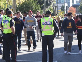Kingston Police officers monitor the crowd on Aberdeen Street on Oct. 15 during Homecoming weekend at Queen's University. (Steph Crosier/The Whig-Standard)