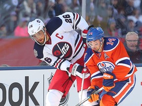 Winnipeg Jets right winger Blake Wheeler (l) and Edmonton Oilers right winger Jordan Eberle fight for the puck during NHL Heritage Classic hockey in Winnipeg, Man. Sunday October 23, 2016. Brian Donogh/Winnipeg Sun/Postmedia Network