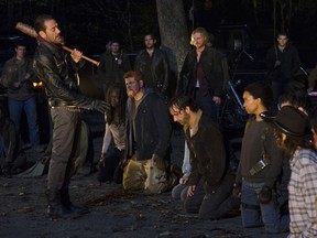 In this image released by AMC, Jeffrey Dean Morgan, standing left, and kneeling from left, Danai Gurira, Michael Cudlitz, Andrew Lincoln and Sonequa Martin-Green appear in a scene from "The Walking Dead." Sunday's cliffhanger ending to its sixth season fascinated more than 14 million viewers. (Gene Page/AMC via AP)