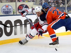 Darnell Nurse checks Winnipeg Jets' Shawn Matthias during second-period action Sunday at the Heritage Classic in Winnipeg. (The Canadian Press)