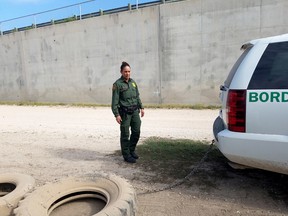 U.S. Border Patrol agent Raquel Medina prepares to drag tires across a road near the Rio Grande in Texas to smooth out the dirt so that agents can detect migrants' footprints. (Washington Post photo by Lisa Rein)