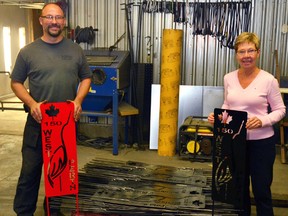 Posing with a pallet of unpainted West Perth Canada 150 garden stakes, Mitchell Iron Works owner Brad Brace (left) and West Perth Tourism and Community Beautification Committee member Joan Tam show off two examples of the finished product, which will soon be available for purchase up until Canada Day, 2017. GALEN SIMMONS MITCHELL ADVOCATE
