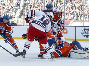 Drew Stafford #12 of the Winnipeg Jets tries to jam the puck past Cam Talbot #33 of the Edmonton Oilers during the 2016 Tim Hortons NHL Heritage Classic hockey game on October 23, 2016.