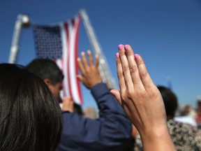 One hundred immigrants become American citizens during a naturalization ceremony at Liberty State Park on September 17, 2015 in Jersey City, New Jersey. The group, representing 30 countries, took the oath of allegiance to the United States on U.S. Citizenship Day.  (Photo by John Moore/Getty Images)