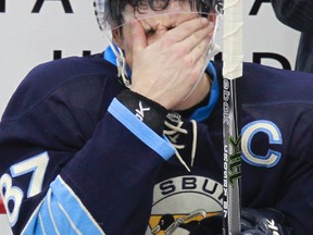 In this Nov. 25, 2011, file photo, Pittsburgh Penguins' Sidney Crosby sits on the bench during a time out in an NHL hockey game against the Ottawa Senators in Pittsburgh. (AP Photo/Gene J. Puskar, File)