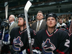 From left, Henrik Sedin, head coach Marc Crawford and Daniel Sedin look on from the Canucks bench during the 2005 season. Crawford is back in Vancouver as an associate coach with the Senators to face the Canucks tonight. (Getty Images)