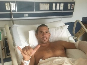 In this Friday, Oct. 21, 2016 photo provided by Kari Feinstein, surfer Federico Jaime poses for a photo from his hospital bed in Wailuku, Hawaii. Jaime was surfing Friday at a beach about two blocks from his Paia home when he felt a shark chomp down on his left arm, he recalled Monday, Oct. 24, from his room at Maui Memorial Medical Center. Jamie says he's grateful to be recovering in a Maui hospital after a shark bit him — even though the attack forced him and his wife, Kari Feinstein, to postpone their honeymoon. (Kari Feinstein via AP)