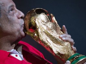In this April 22, 2014 file photo, former Brazilian soccer captain Carlos Alberto Torres kisses the World Cup trophy which is part of the FIFA World Cup Trophy Tour, at the Maracana Stadium, in Rio de Janeiro, Brazil. (AP/Felipe Dana, File)