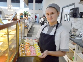 Felecia Burggraaf holds a tray of petit fours in the bakery section of the new Dutch Market. She is one of the bakers at their new location at the corner of William Street and Park Street, which had its grand opening Oct. 22.