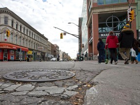 A pedestrian crosses Richmond Street at Dundas Street. Downtown London said a Toronto consulting firm has given good value in its assessment of city plans to turn a stretch of Dundas Street into a vehicle-optional public space. (CRAIG GLOVER, The London Free Press)