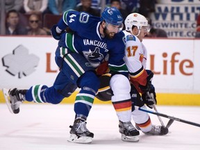 Vancouver Canucks defenceman Erik Gudbranson battles Calgary Flames centre Lance Bouma earlier this season. (The Canadian Press)