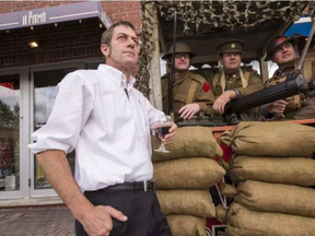 Preston Street il Primo restaurant owner Craig Pedersen on the front steps of his business with First World War Re-enactors (L-R) Daniel Ferland, Rich Lees, and Terry Hunter in a machine gun nest. (Errol McGihon, Postmedia)