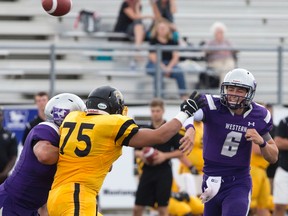 Western Mustangs quarterback Ben Bergamin throws a pass by Waterloo Warriors defensive end Michael Cleirbaut during their OUA football game at TD Stadium in London, Ont. on Saturday September 10, 2016. (Free Press file photo)