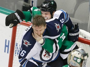 Winnipeg Jets right wing Blake Wheeler (26) tangles with Dallas Stars left wing Jamie Benn (14) as goalie Antti Niemi (31) looks on during the third period of an NHL hockey game Tuesday, Oct. 25, 2016, in Dallas. The Stars won 3-2. (AP Photo/LM Otero)