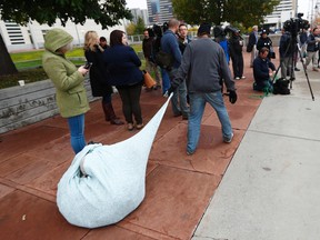 In this Wednesday, Oct. 12, 2016, photograph, an unidentified man drags his belongings to join a brief rally before entering the federal courthouse for a hearing in a class action lawsuit challenging the homeless sweeps in the Mile High City last spring in Denver. The lawsuit is the latest in a string of cases opposing crackdowns on people camping in public around the country. (AP Photo/David Zalubowski)