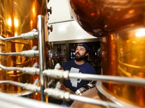 Head brewer Spike Baker checks his still as a cleanup crew works inside Wood Buffalo Brewing Company in Fort McMurray, Alta., on Thursday June 9, 2016.Ian Kucerak/Postmedia