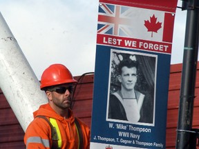 The municipality's Shawn Bechard works on hanging a banner honouring a local veteran on James Street, on Thursday, Oct. 13. Twenty-five banners honouring and celebrating local veterans were hung last week and they will remain up until after Remembrance Day.