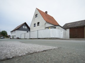 In this Sept.19, 2016 file picture af ence hides part of a house in Hoexter, Germany. A couple accused of luring women to their home in Hoexter western Germany and abusing them so badly that two of them died are going on trial. Forty-six-year-old Wilfried W. and his 47-year-old ex-wife, Angelika W., are charged with murder by omission and bodily harm in the trial that opened Wednesday Oct. 26, 2016 in Paderborn. Their full names weren't given in keeping with German privacy rules. (Friso Gentsch/dpa via AP,file)