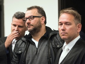 Defendant Wilfried W., centre, is framed by his lawyers Detlev Binder, left, and Carsten Ernst as he arrives at the court in Paderborn, Germany, Wednesday Oct. 26, 2016. (Bernd Thissen/dpa via AP)