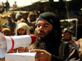 Two men are stoned to death for reportedly committing adultery in front of a crowd in the square in Abu Kamal in eastern Syria in this photo released by ISIS. Handout/Postmedia Network