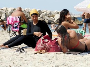 A file photo shows a woman (left) in a burkini.