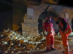 Rescuers stand by rubble in the village of Visso, central Italy, Wednesday, Oct. 26, 2016 following an earthquake. A pair of powerful aftershocks shook central Italy on Wednesday, knocking out power, closing a major highway and sending panicked residents into the rain-drenched streets just two months after a powerful earthquake killed nearly 300 people. (Matteo Crocchioni/ANSA via AP)
