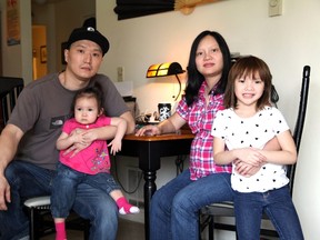 FILE - In this March 19, 2015, file photo, Korean adoptee Adam Crapser, left, poses with daughters, Christal, 1, Christina, 5, and his wife, Anh Nguyen, in the family's living room in Vancouver, Wash. After struggling with joblessness because of his lack of immigration papers, homelessness and crime, Crapser, a South Korean man who was flown to the U.S. 37 years ago and adopted by an American couple at age 3 has been ordered deported back to a country that is completely alien to him, Wednesday, Oct. 26, 2016. (AP Photo/Gosia Wozniacka, File)