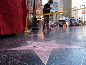 A man stands near a cordoned off area surrounding the vandalized star for Republican presidential candidate Donald Trump on the Hollywood Walk of Fame, Wednesday, Oct. 26, 2016, in Los Angeles. Det. Meghan Aguilar said investigators were called to the scene before dawn Wednesday following reports that Trump's star was destroyed by blows from a hammer. (AP Photo/Richard Vogel)
