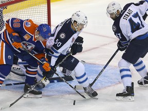Bakersfield Condors center Jere Sallinen (l) battles for the puck with Manitoba Moose center Jack Roslovic (c) and defenceman Brian Strait during AHL hockey in Winnipeg, Man. Thursday October 20, 2016.