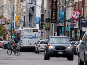A cyclist crosses the intersection of Dundas and Wellington Streets behind a bus, showing several ways Londoners get around. (CRAIG GLOVER, The London Free Press)