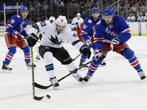San Jose Sharks's Matt Nieto (83) fights for control of the puck with New York Rangers's Dylan McIlrath during the first period of an NHL hockey game, Monday, Oct. 17, 2016, in New York.