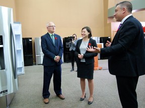 Alberta Environment Minister Shannon Phillips and David Dodge, chair of Energy Efficiency Alberta, receive tips on buying a power-smart refrigerator from Trail Appliances director of sales Michael Seens. BILL MAH/Postmedia