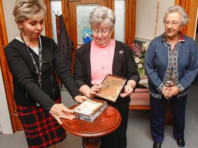 Representatives from Providence Care and Sisters of Providence St. Vincent de Paul look through the contents of a recently discovered time capsule from 1956 at St. Mary’s of the Lake Hospital. (Julia McKay/The Whig-Standard)