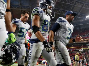 Seahawks quarterback Russell Wilson (3), wide receiver Doug Baldwin (89) and middle linebacker Brock Coyle (52) leave the field after a game against the Cardinals in Glendale, Ariz., on Sunday, Oct. 23, 2016. The game ended in overtime in a 6-6 tie. (AP Photo/Ross D. Franklin)