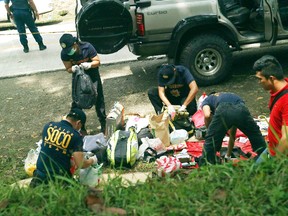 Residents watch as police inspect the contents of the vehicles following an operation Friday, Oct. 28, 2016 at Makilala township, North Cotabato province in southern Philippines. (AP Photo)