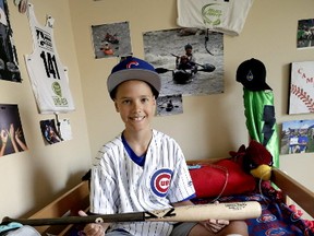 Campbell Faulkner, 10, shows his custom-made baseball bat given to him by Chicago Cubs' Kyle Schwarber, at his home in Queen Creek, Ariz., Thursday, Oct. 27, 2016. (AP Photo/Matt York)