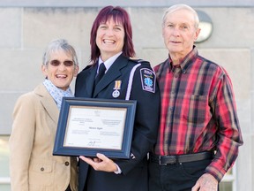 Proud parents Doreen, left, and Bill Taylor, far right, pose for a photo with their daughter Marion Taylor outside the county courthouse Oct. 19 after Huron council congratulated her and three other local paramedics on their accomplishment. (Darryl Coote/The Goderich Signal Star)