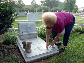 Lib Waters places a note on the grave of JonBenet Ramsey August 16, 2006 in Marietta, Georgia. (Barry Williams/Getty Images)